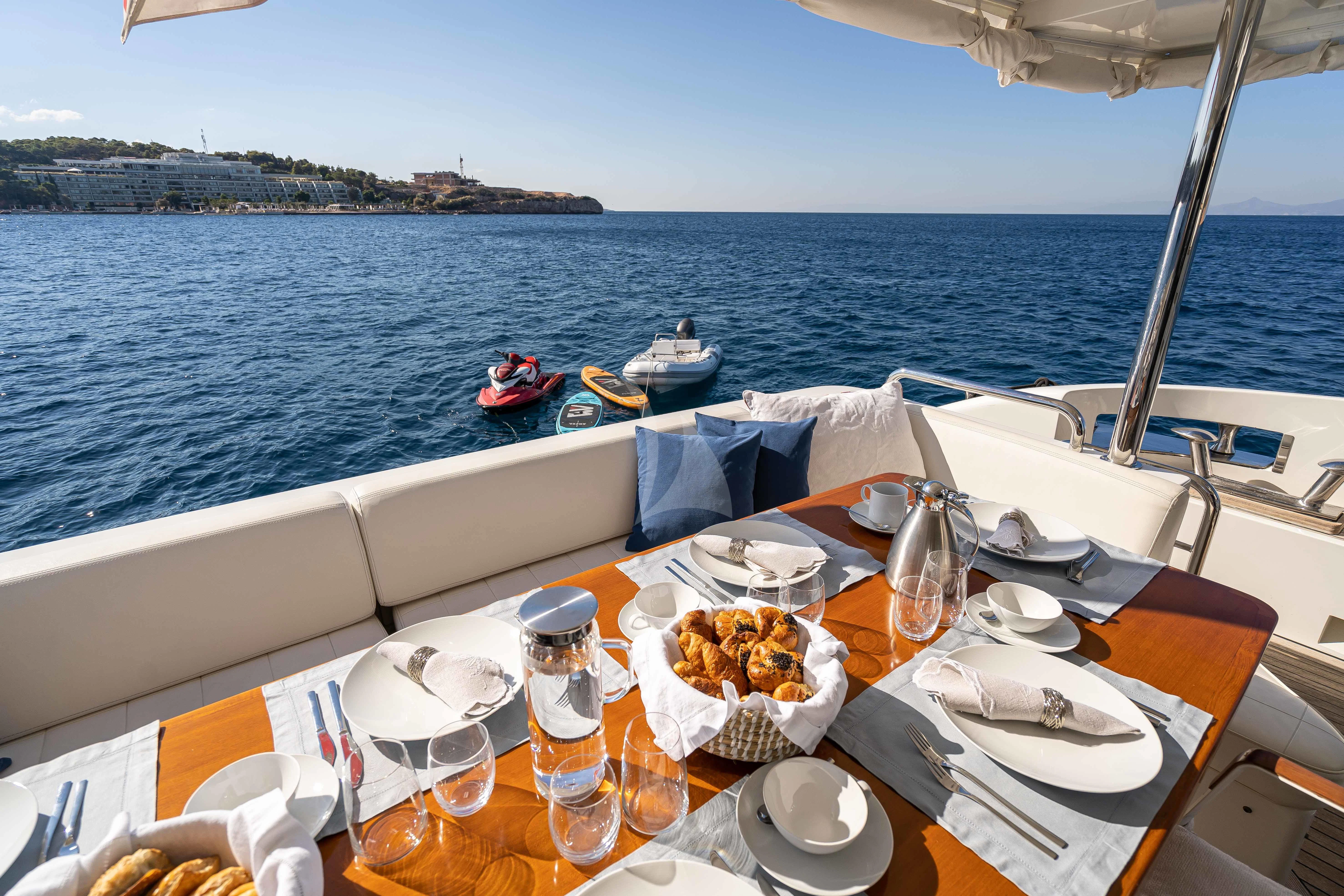 a table with food on it by the water aboard KOUKLES Yacht for Sale