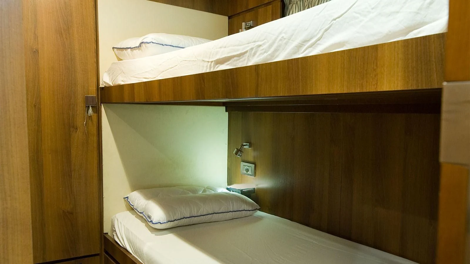 a bed with a wooden headboard aboard KOUKLES Yacht for Sale