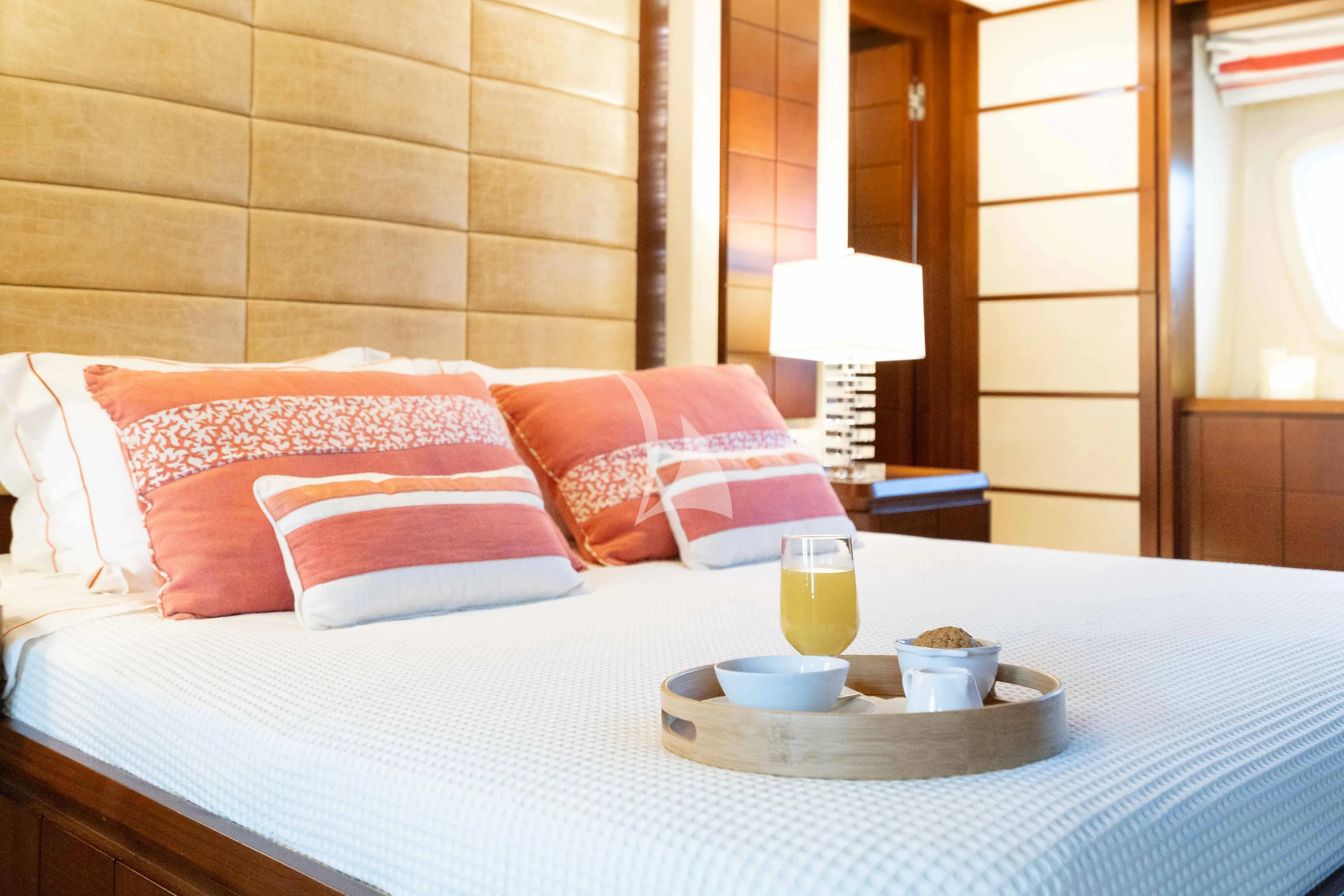 a bed with a tray of food and drinks on it aboard KOUKLES Yacht for Sale