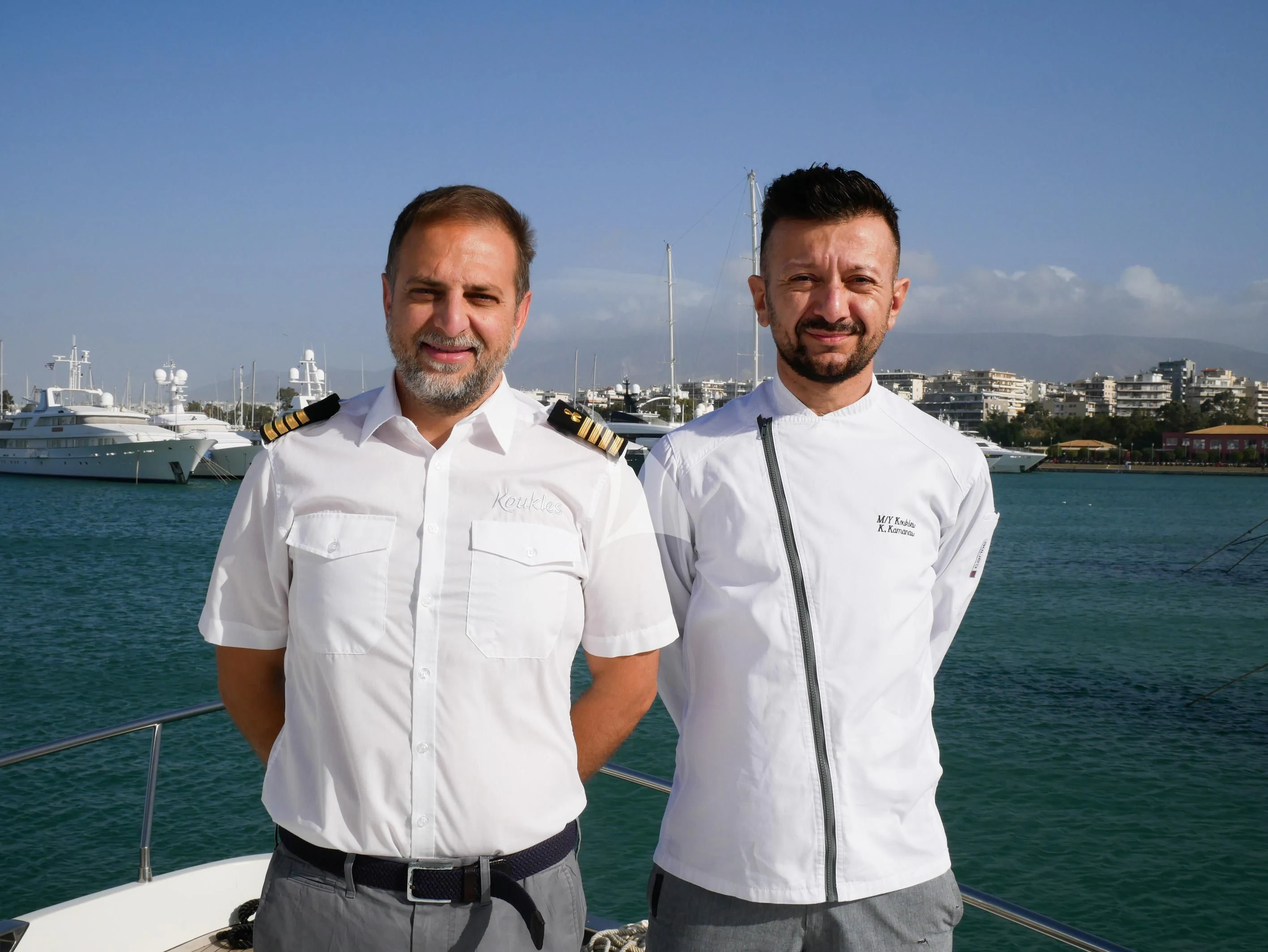 two men standing in front of a body of water aboard KOUKLES Yacht for Sale