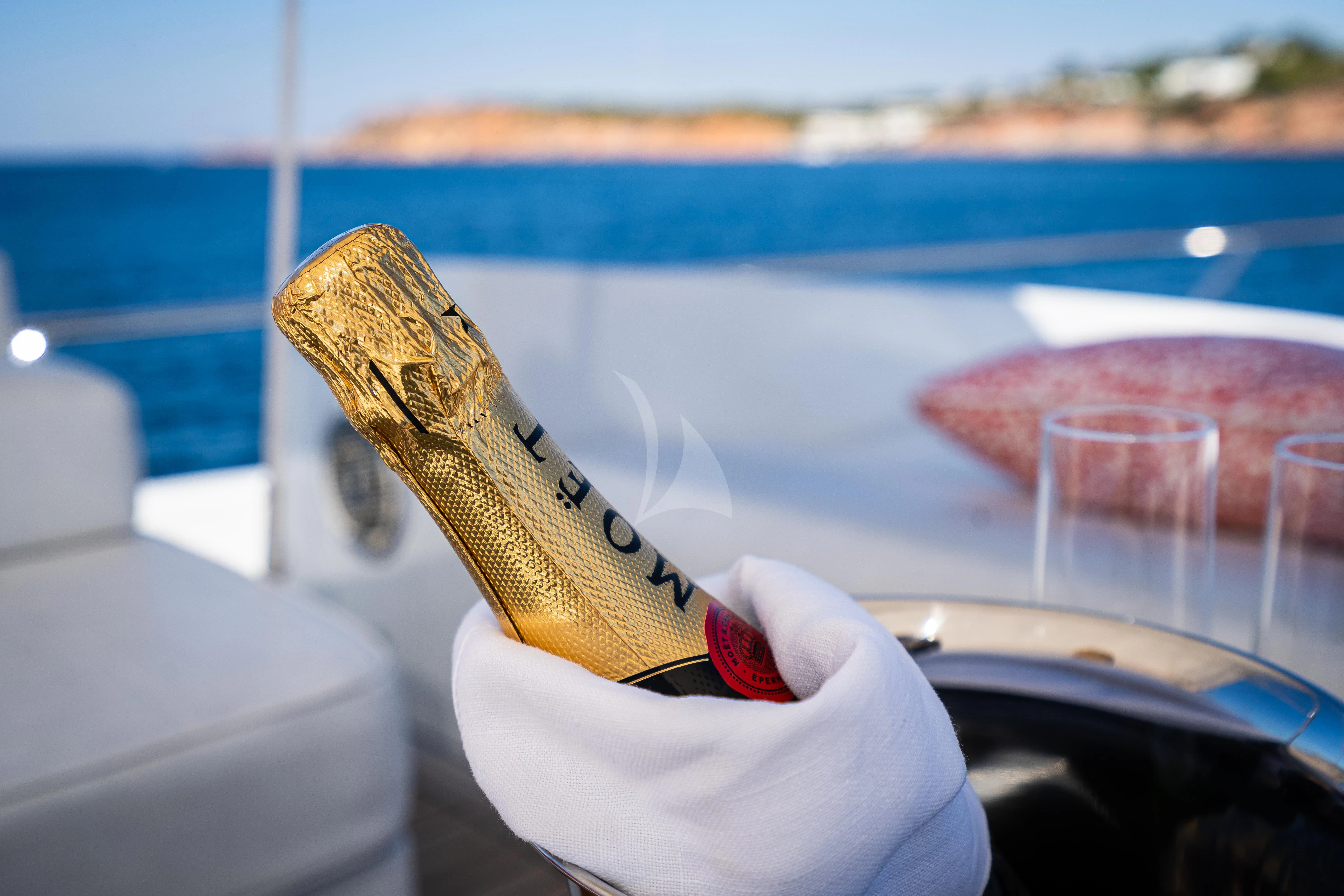 a hand holding a gold colored shoe aboard KOUKLES Yacht for Sale