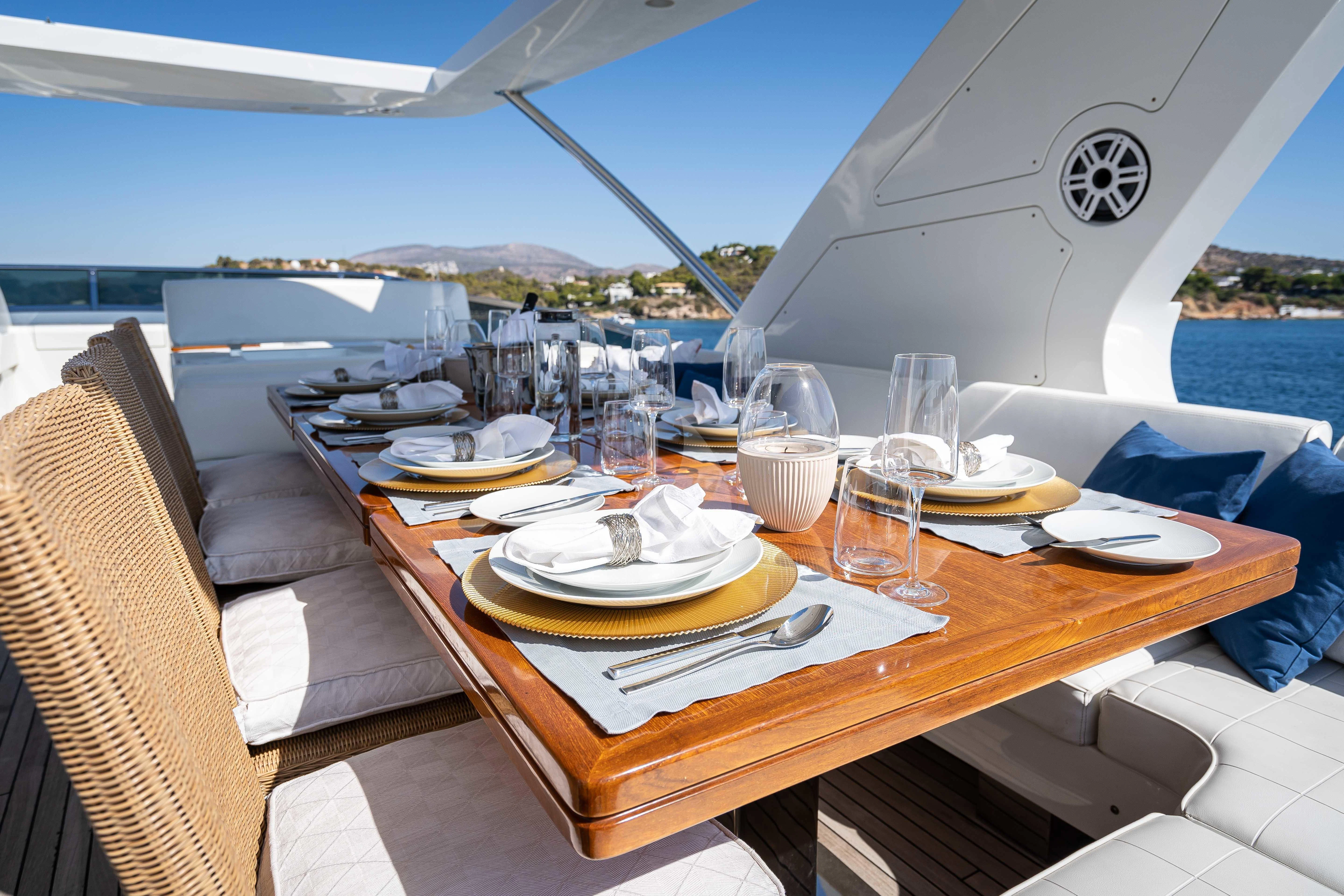 a table with plates and glasses on it aboard KOUKLES Yacht for Sale