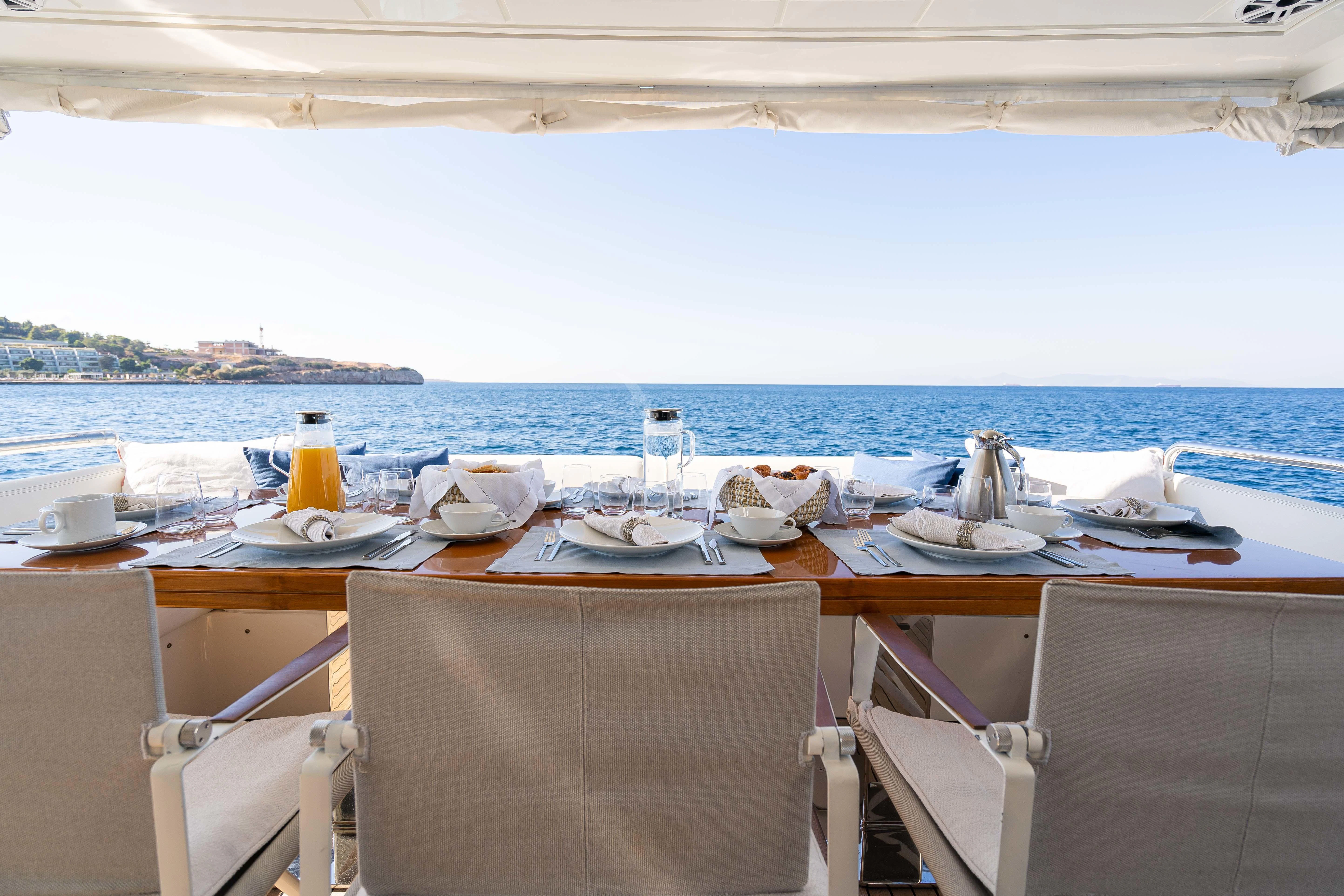 a table with plates and glasses on it aboard KOUKLES Yacht for Sale