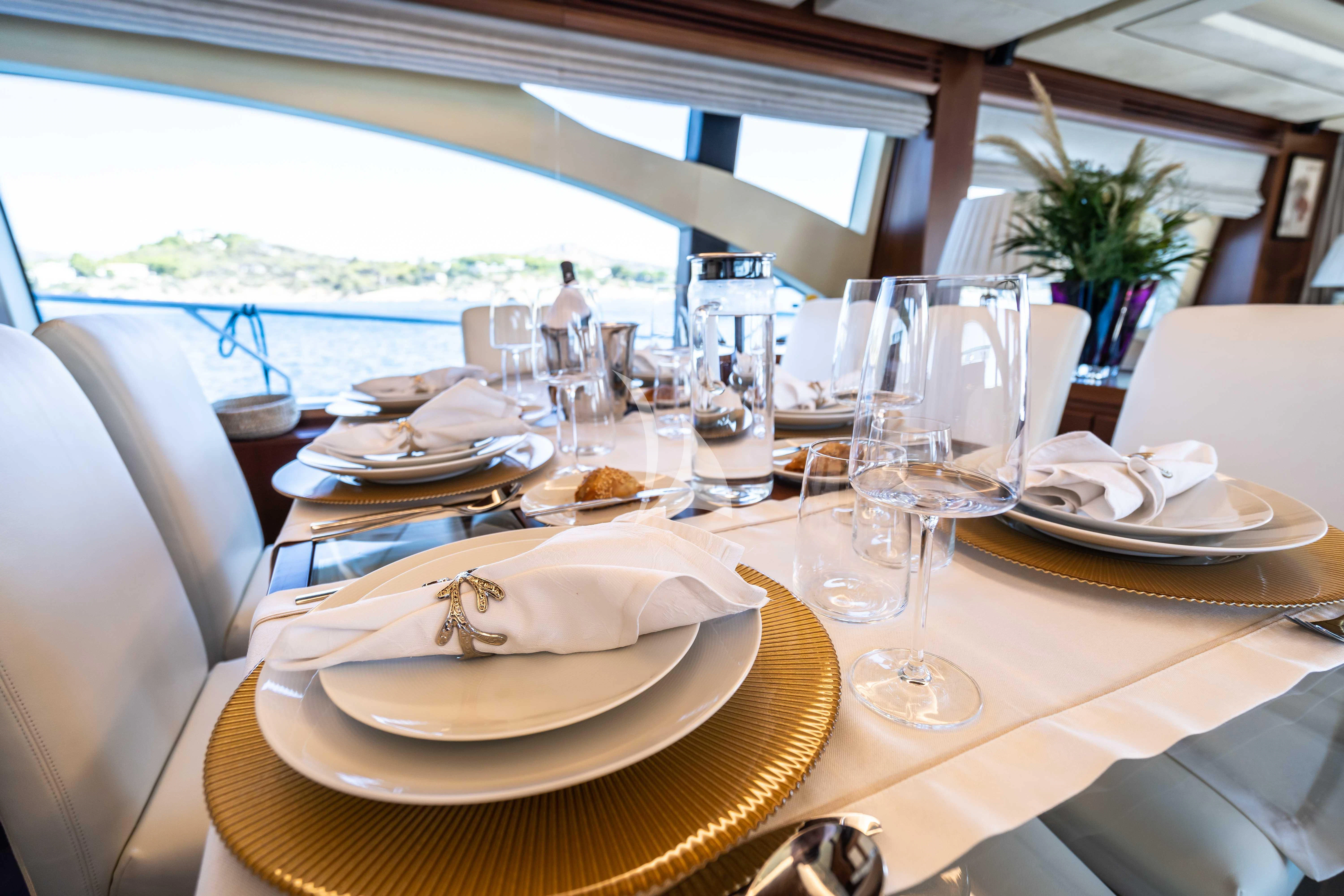 a table with plates and glasses aboard KOUKLES Yacht for Sale