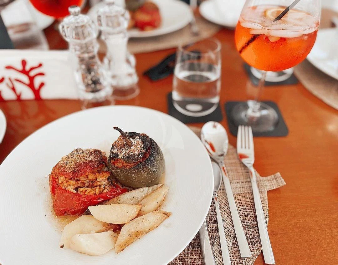 a plate of food and glasses of beer aboard KOUKLES Yacht for Sale