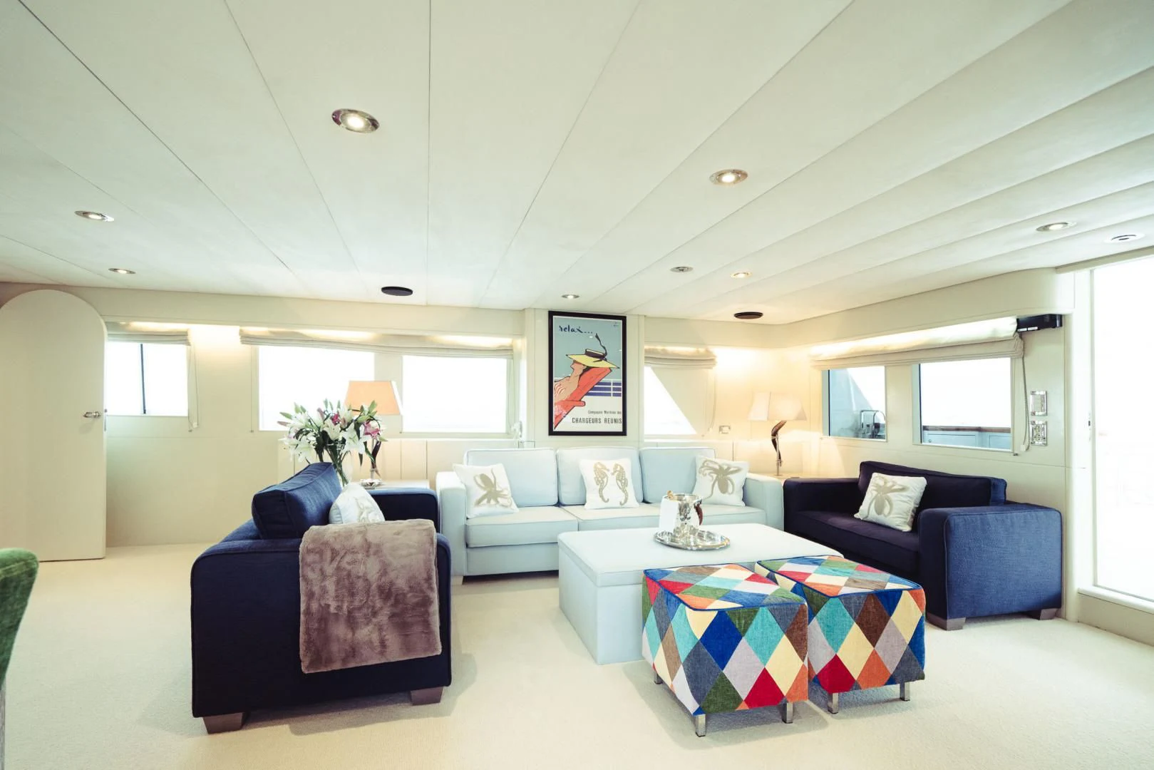 a living room with blue couches aboard WIZARD ONE Yacht for Sale