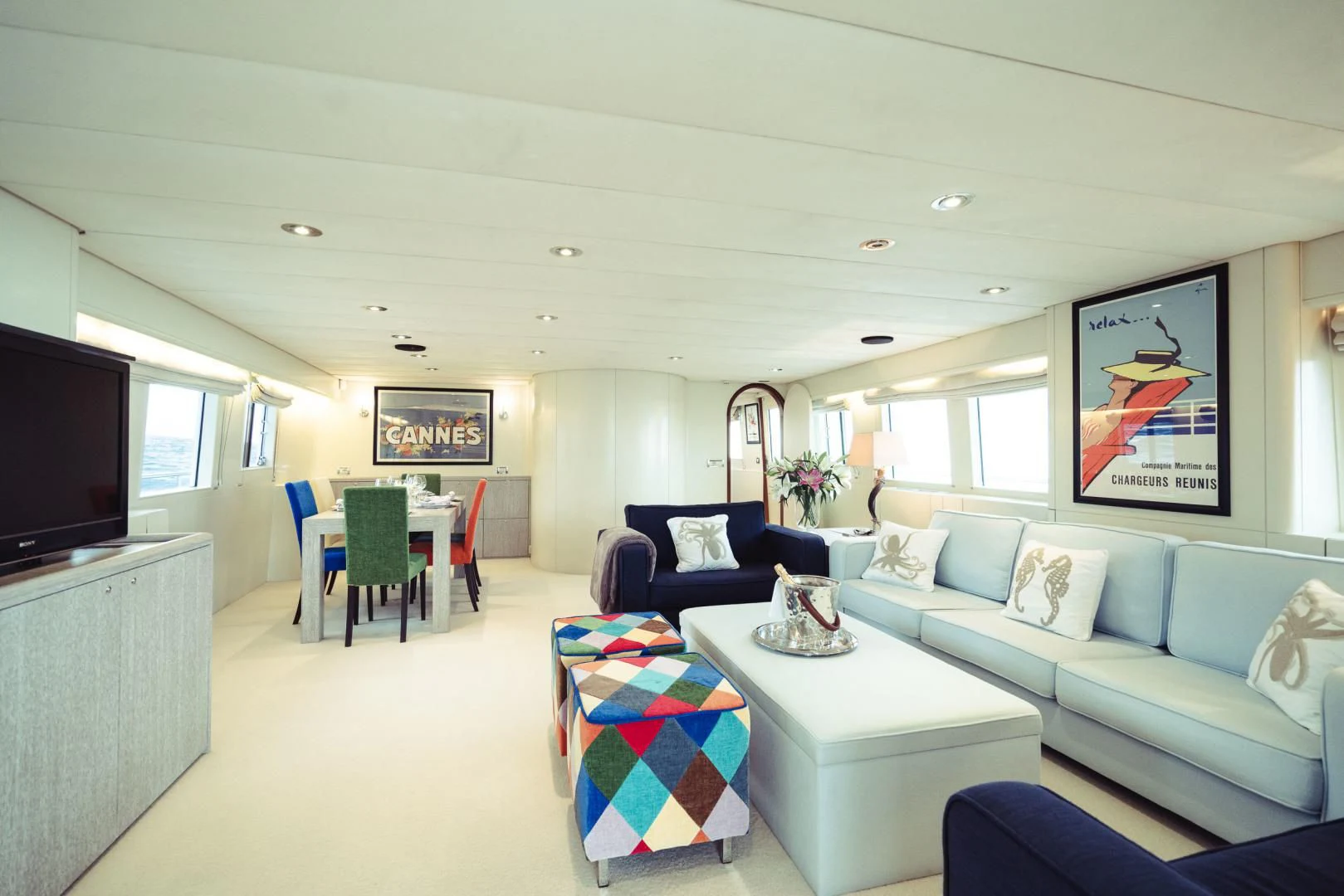 a living room with a blue couch and a television aboard WIZARD ONE Yacht for Sale