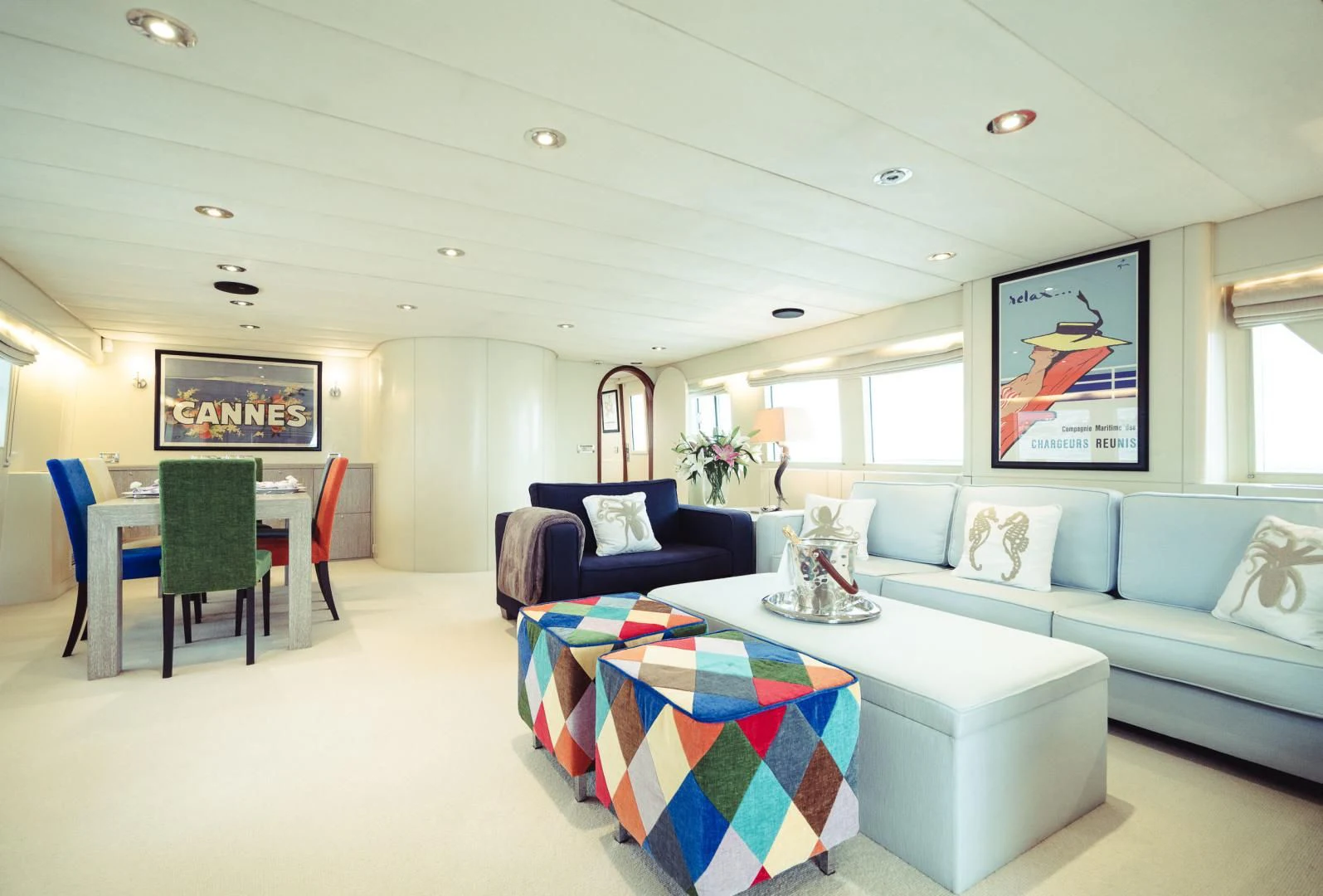 a living room with a blue couch and a table aboard WIZARD ONE Yacht for Sale
