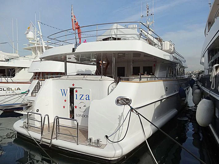 a white boat in a harbor aboard WIZARD ONE Yacht for Sale