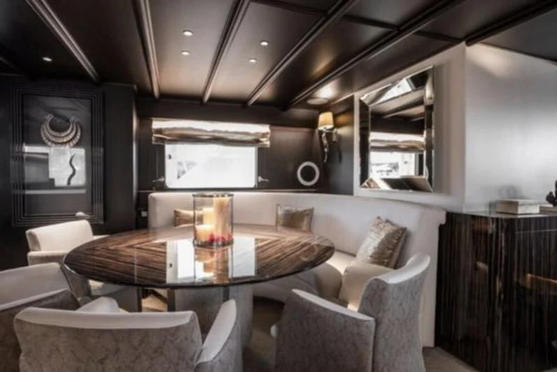 a room with a table chairs and a couch aboard RA Yacht for Sale