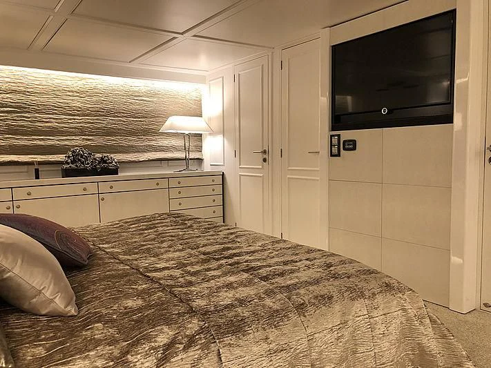 a bedroom with a bed and tv aboard RA Yacht for Sale