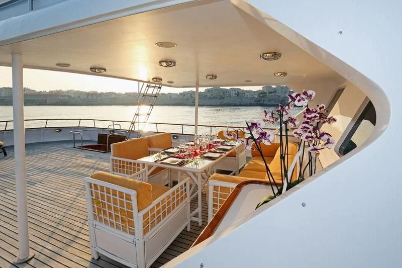 a boat with a table and chairs aboard RA Yacht for Sale