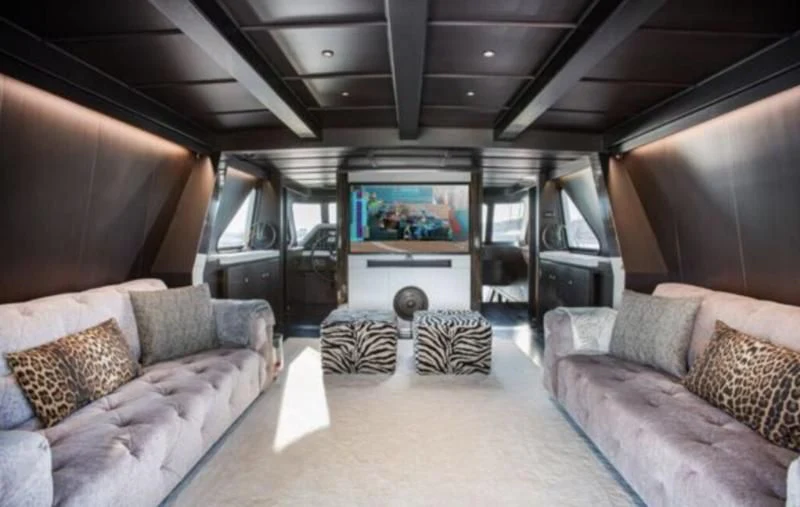 a living room with a large screen aboard RA Yacht for Sale