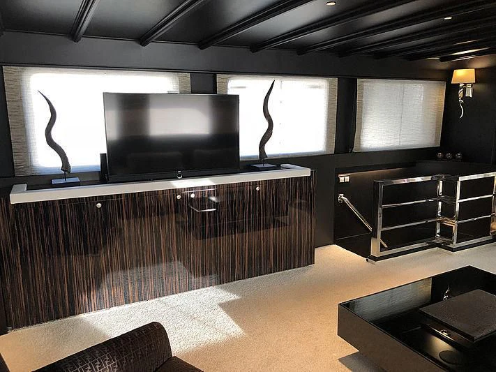 a room with a tv and a couch aboard RA Yacht for Sale