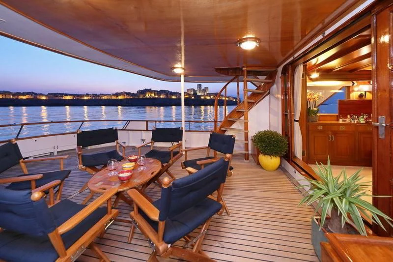 a room with a table and chairs aboard RA Yacht for Sale
