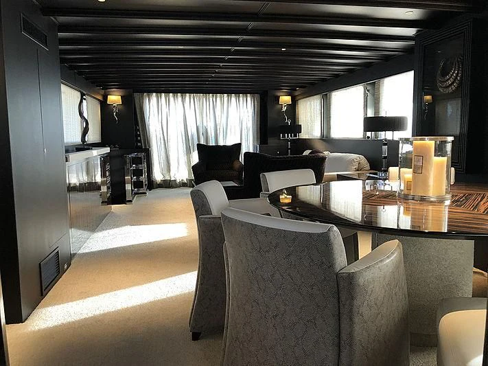 a living room with a table and chairs aboard RA Yacht for Sale