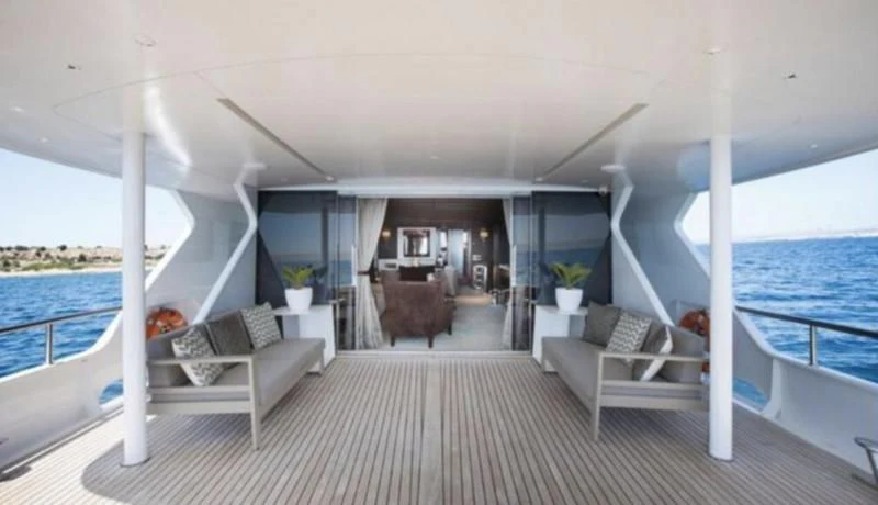 a large open area with a couch and a table and chairs aboard RA Yacht for Sale