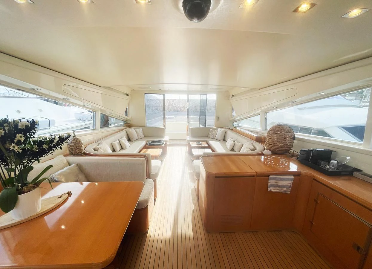 a living room with a wood table and a large window aboard NAISCA IV Yacht for Sale