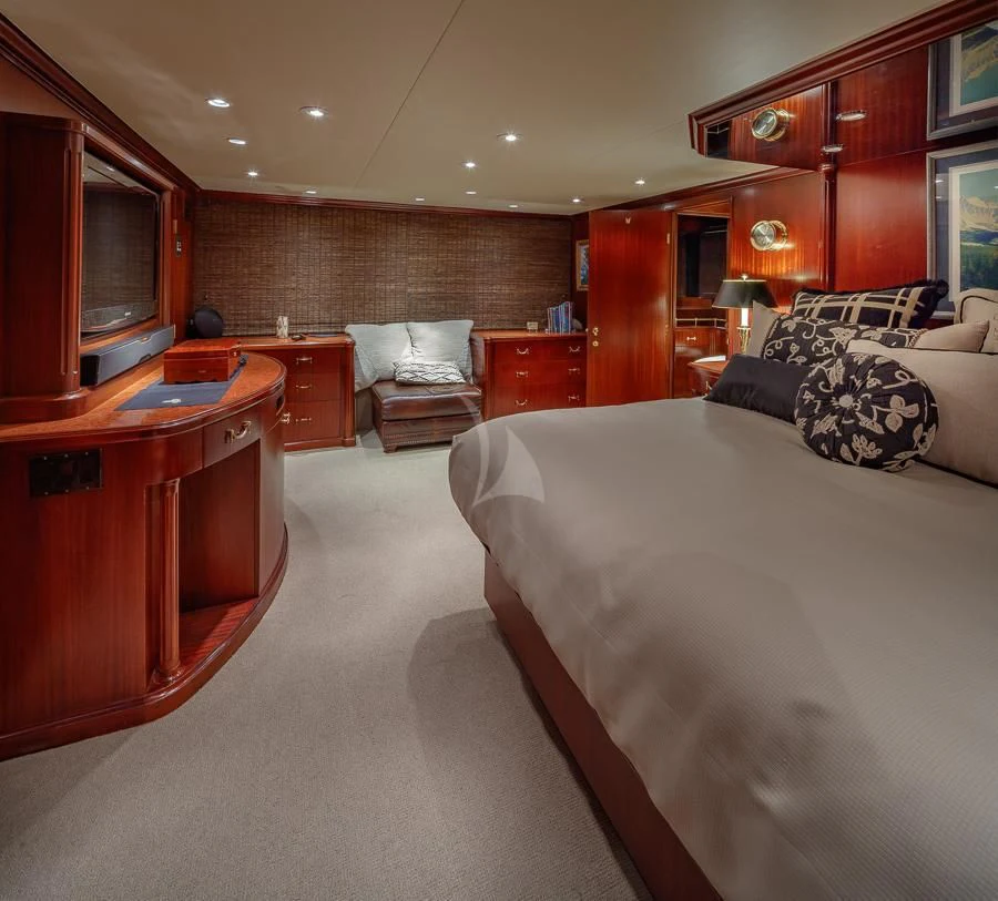 a bedroom with a bed and desk aboard BLACKWOOD Yacht for Sale