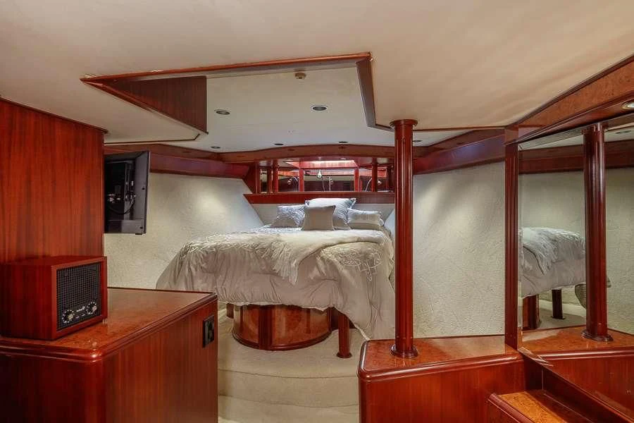 a bedroom with a bed and a desk aboard BLACKWOOD Yacht for Sale