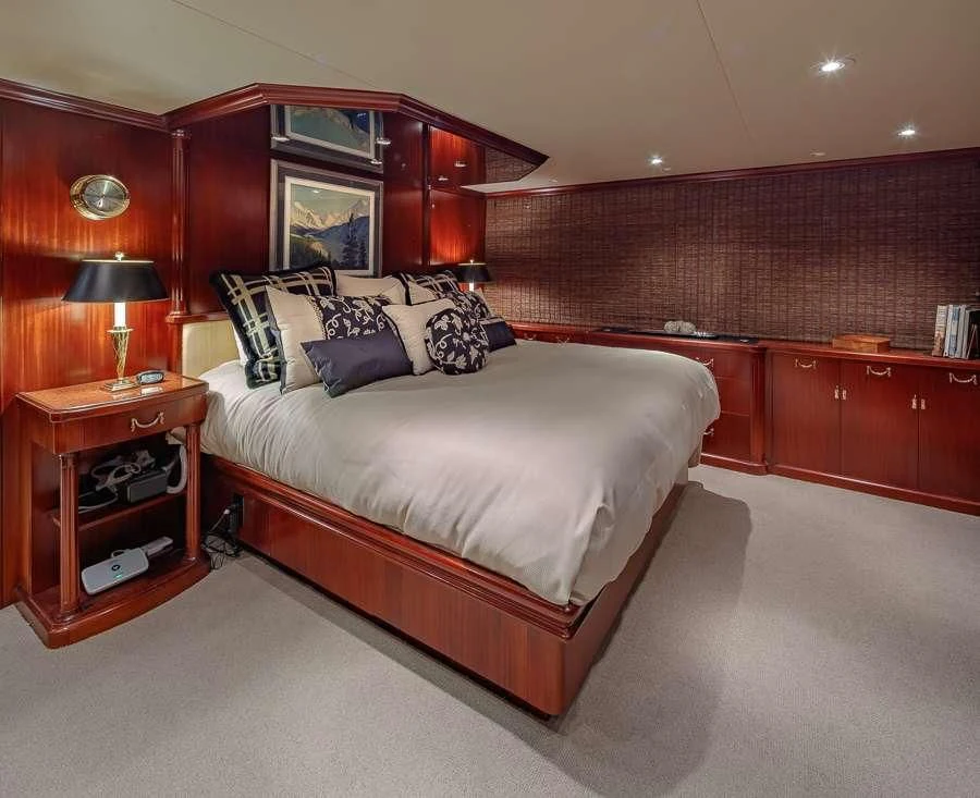 a bedroom with a bed and a desk aboard BLACKWOOD Yacht for Sale