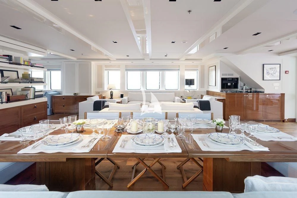a large room with tables and chairs aboard BLUE II Yacht for Charter