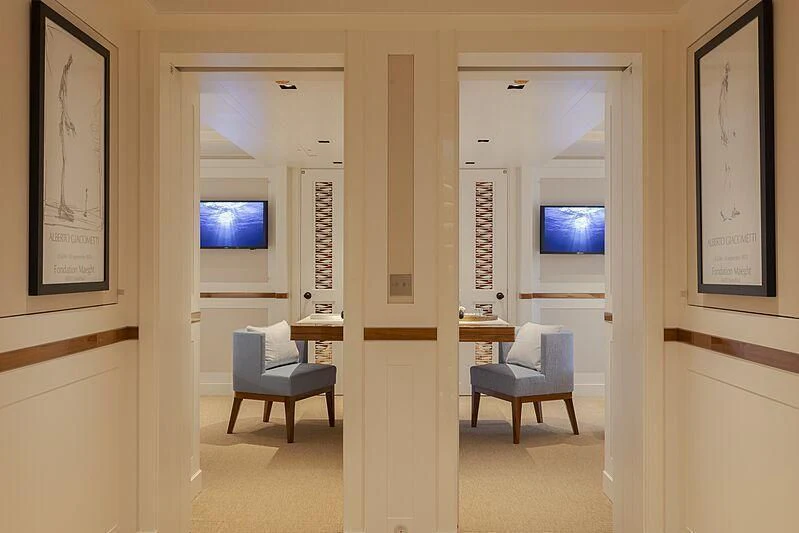 a room with a tv and chairs aboard BLUE II Yacht for Charter