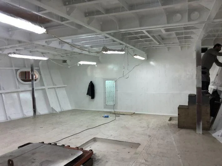 a room with a large hole in the wall and a few people standing aboard BLUE II Yacht for Charter