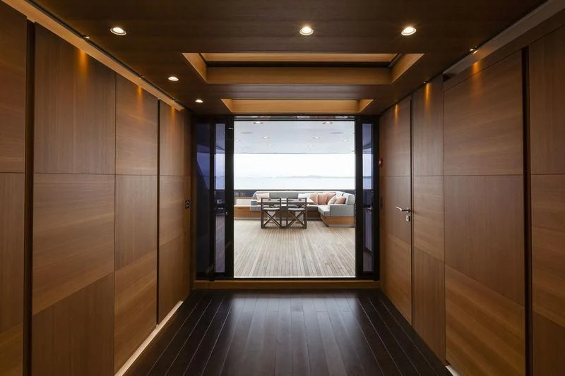 a room with a wood floor and a large window aboard PACHAMAMA Yacht for Sale