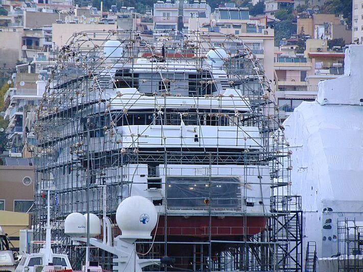 a large white ship in a harbor aboard NOURAH OF RIYAD Yacht for Sale