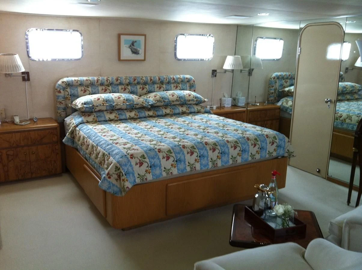 a bedroom with a bed and a lamp aboard ZANTINO III Yacht for Sale