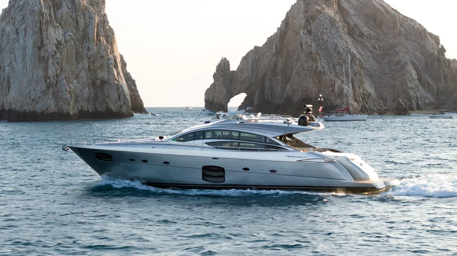 a boat in the water with Arch of Cabo San Lucas in the background aboard UPTOWN GIRL Yacht for Sale