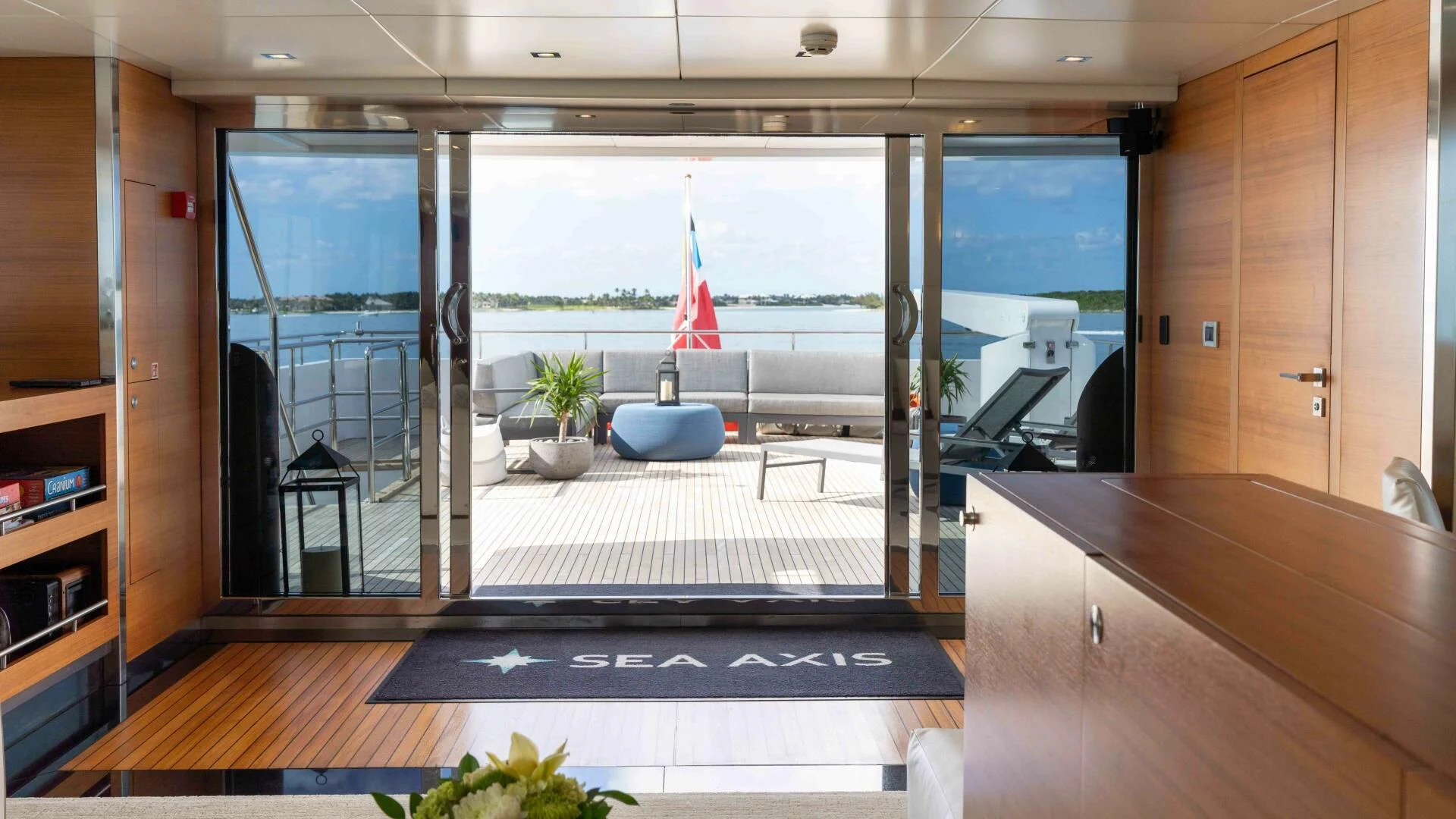 a room with a large window and a table with a chair and a boat in the water aboard SEA AXIS Yacht for Charter