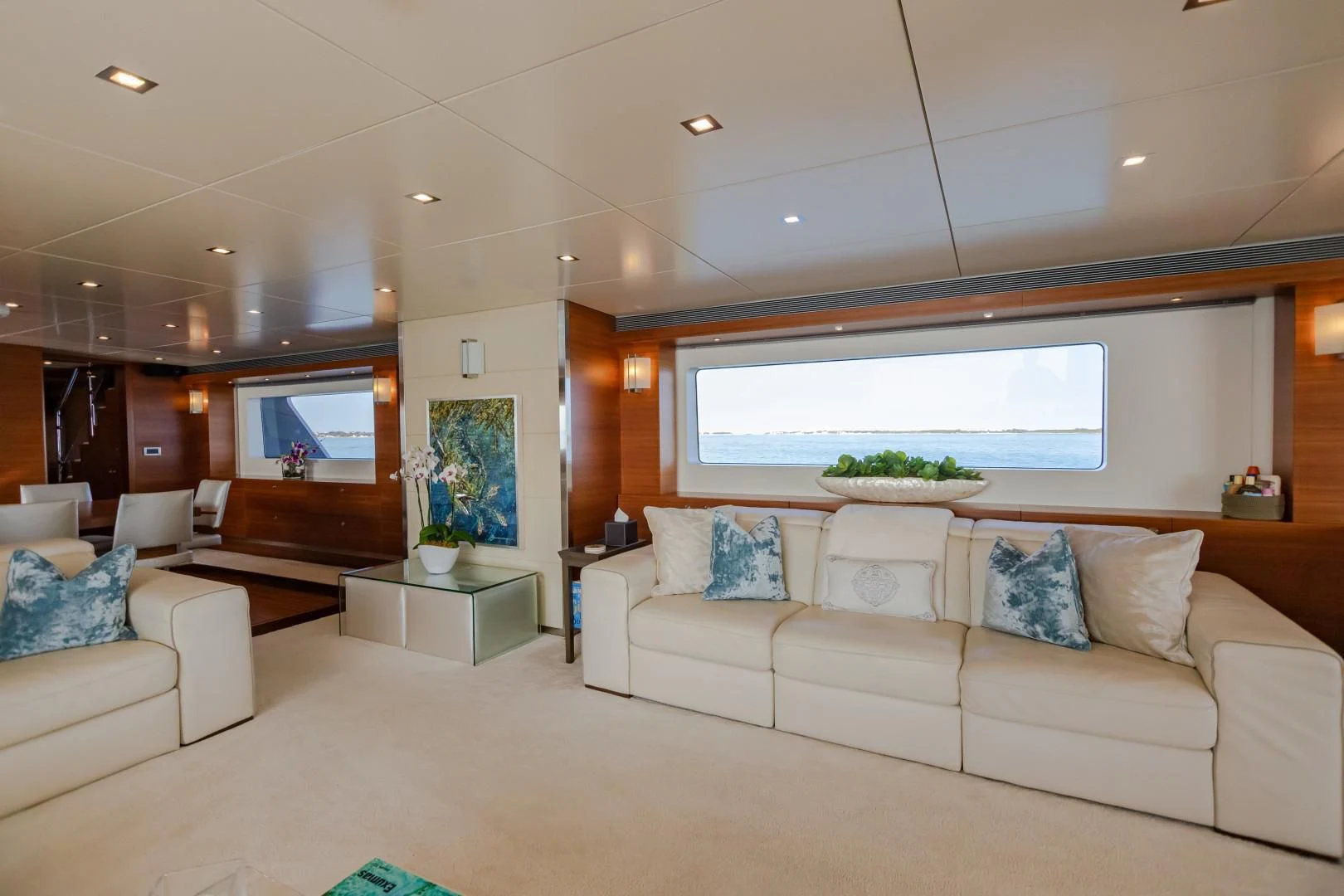 a living room with a large white couch and a large window aboard SEA AXIS Yacht for Charter