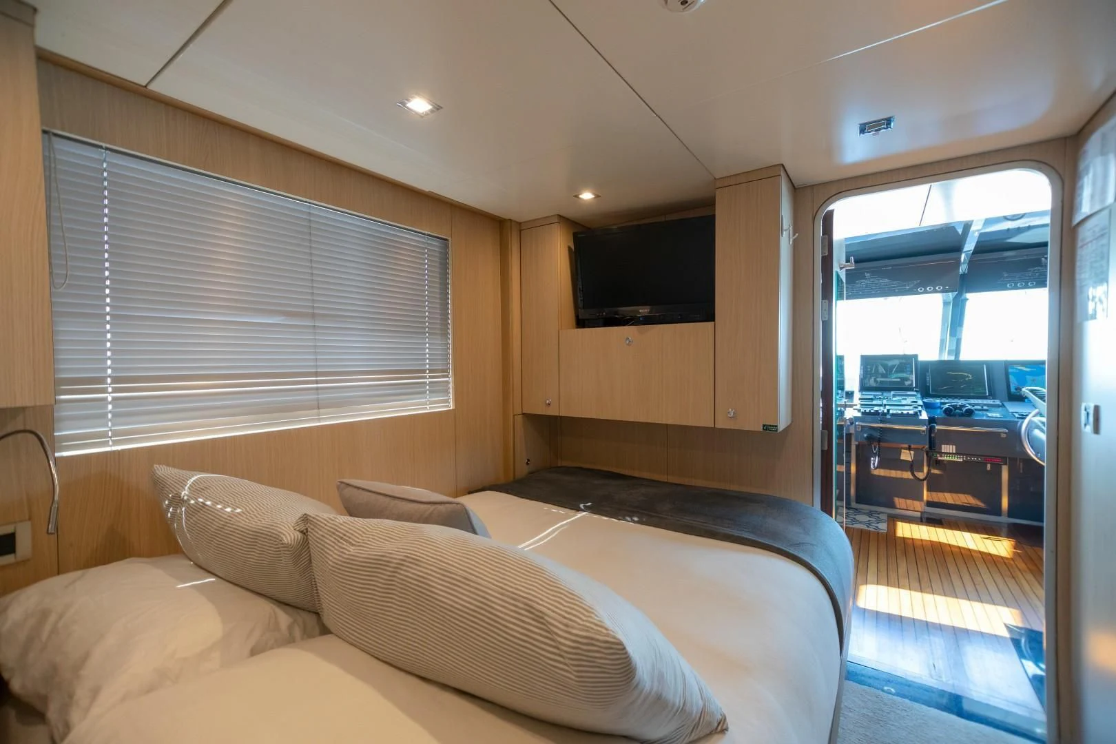 a bedroom with a bed and a sliding glass door aboard SEA AXIS Yacht for Charter