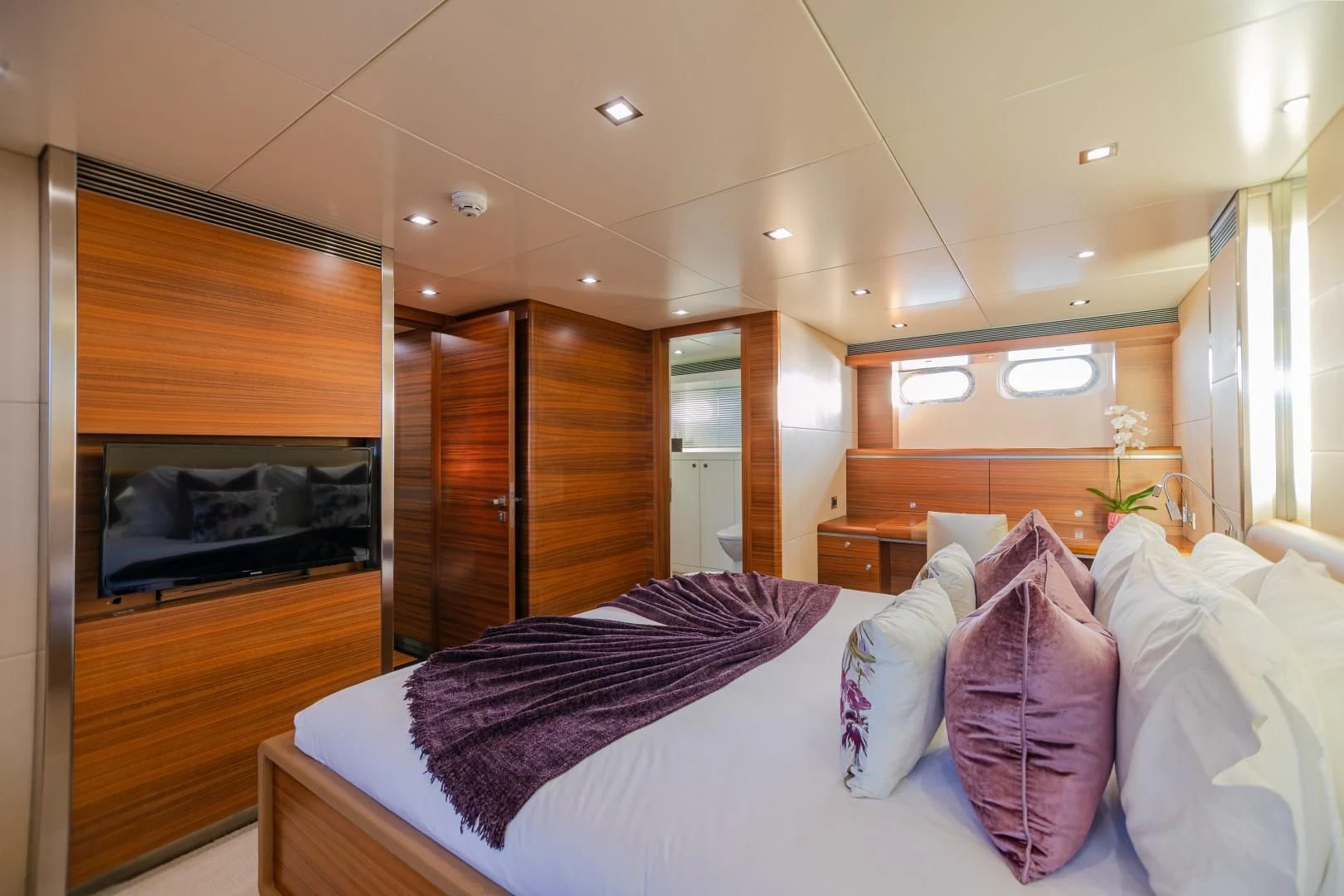 a bedroom with a bed and a television aboard SEA AXIS Yacht for Charter