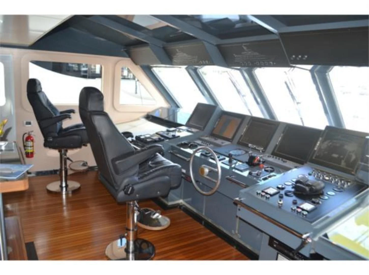 a room with a chair and a desk with computers aboard SEA AXIS Yacht for Charter