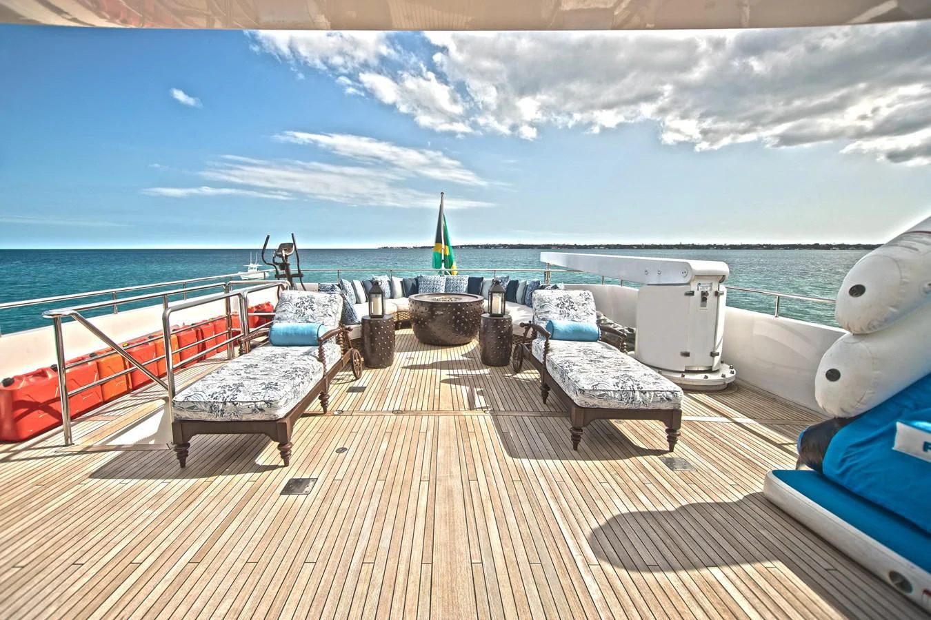 a deck with a view of the ocean and a large boat aboard SEA AXIS Yacht for Charter