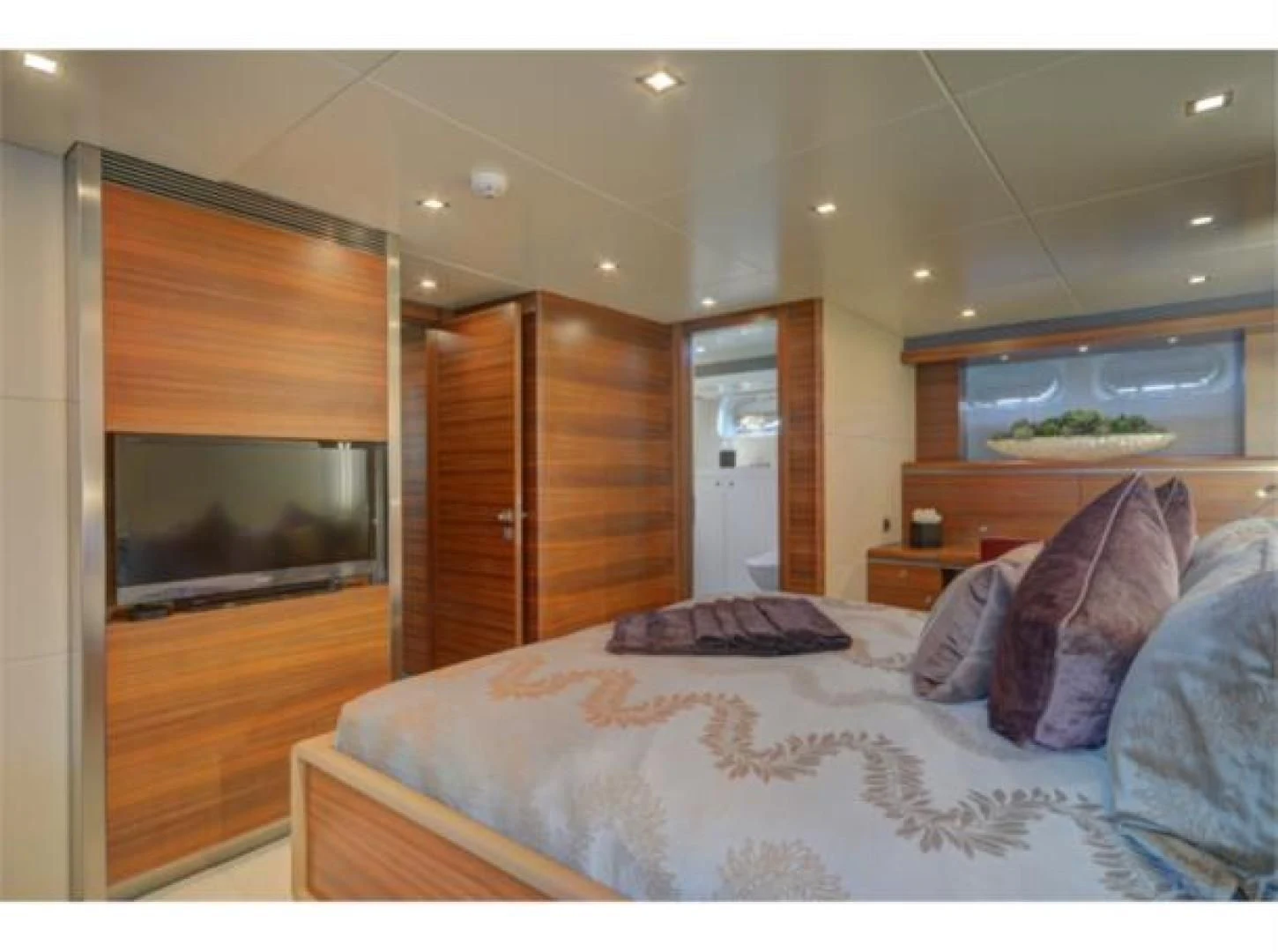 a bedroom with a bed and a television aboard SEA AXIS Yacht for Charter