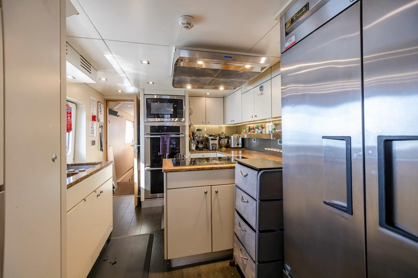 a kitchen with a fridge and cabinets aboard SEA AXIS Yacht for Charter