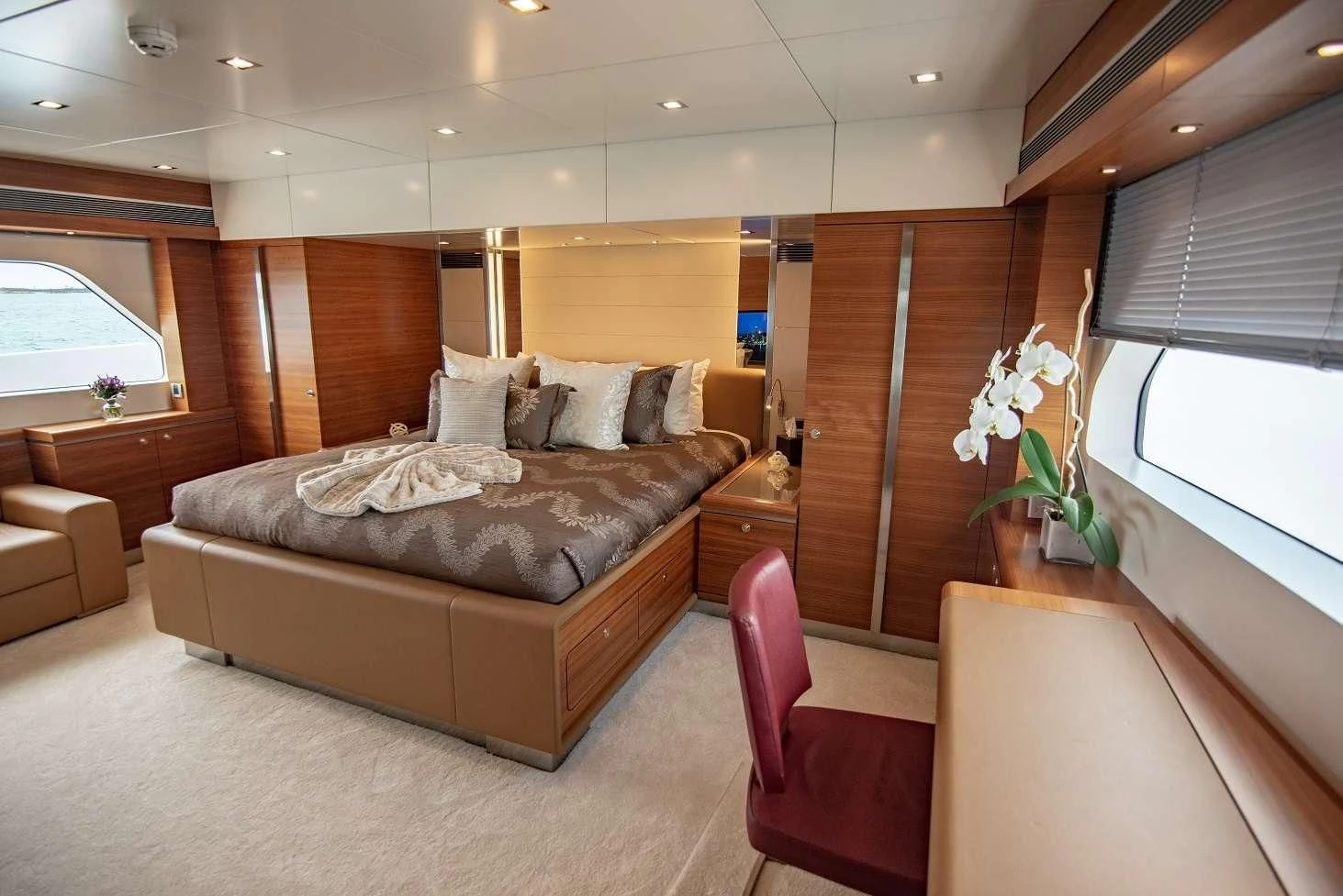 a bedroom with a bed and a chair aboard SEA AXIS Yacht for Charter
