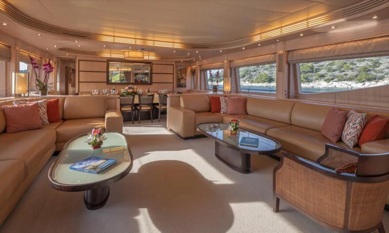 a living room with a table and couches aboard GLAROS Yacht for Sale