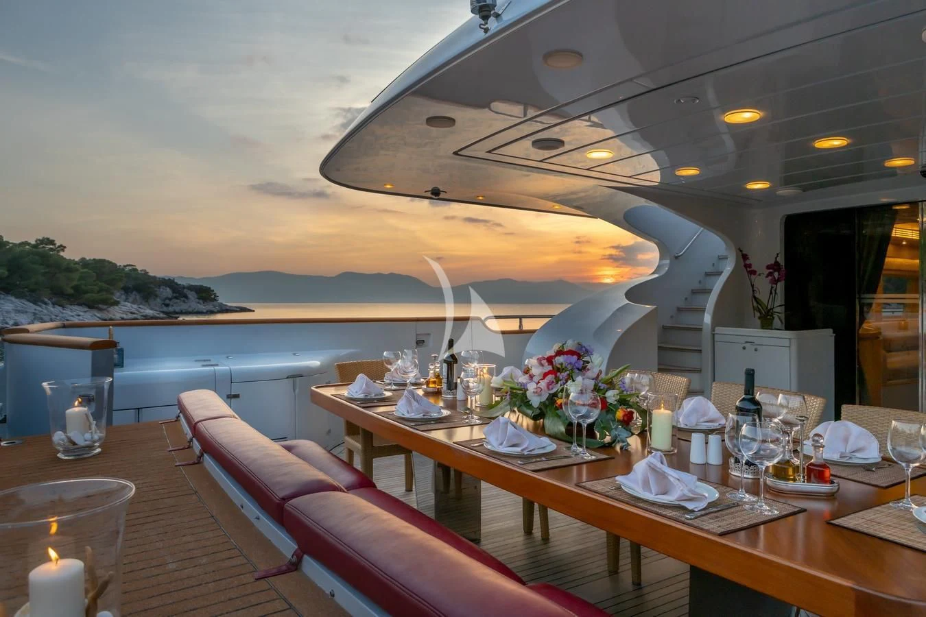 a table with candles and flowers on it aboard GLAROS Yacht for Sale
