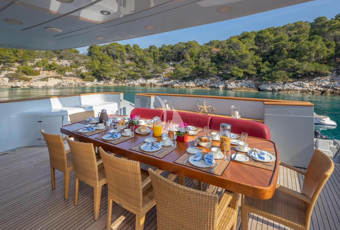 a table set for a meal on a deck overlooking a lake aboard GLAROS Yacht for Sale