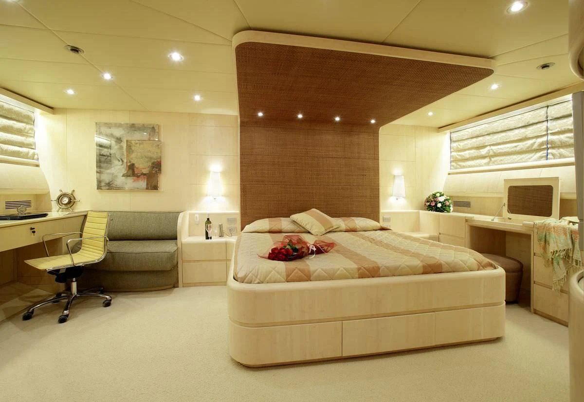 a large bedroom with a bed and a desk aboard GLAROS Yacht for Sale