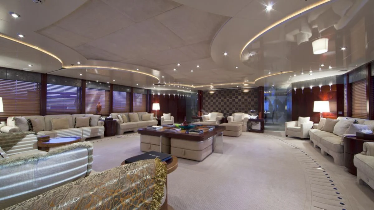 a large living room with a large white couch and a large window aboard SARAH Yacht for Sale