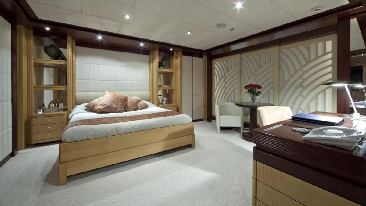 a bedroom with a bed desk and a bookcase aboard SARAH Yacht for Sale