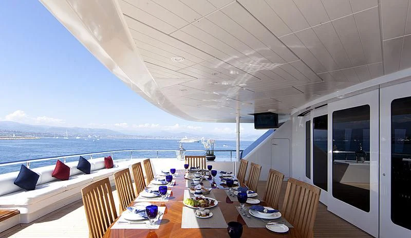 a large white room with a table and chairs and a large body of water aboard SARAH Yacht for Sale