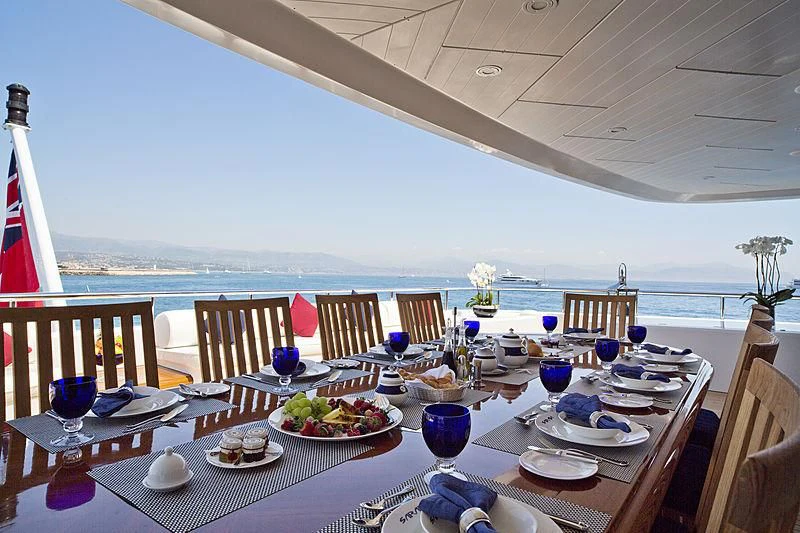 a table set for a meal on a balcony overlooking the ocean aboard SARAH Yacht for Sale