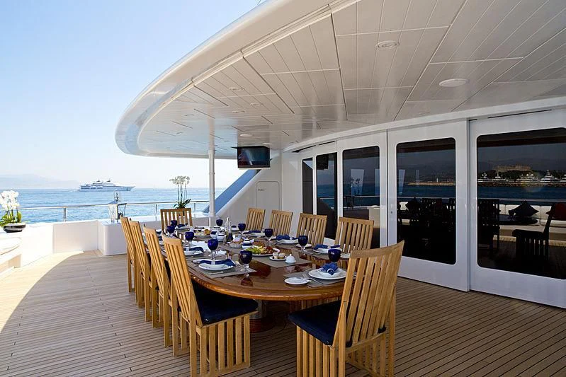 a deck with tables and chairs aboard SARAH Yacht for Sale